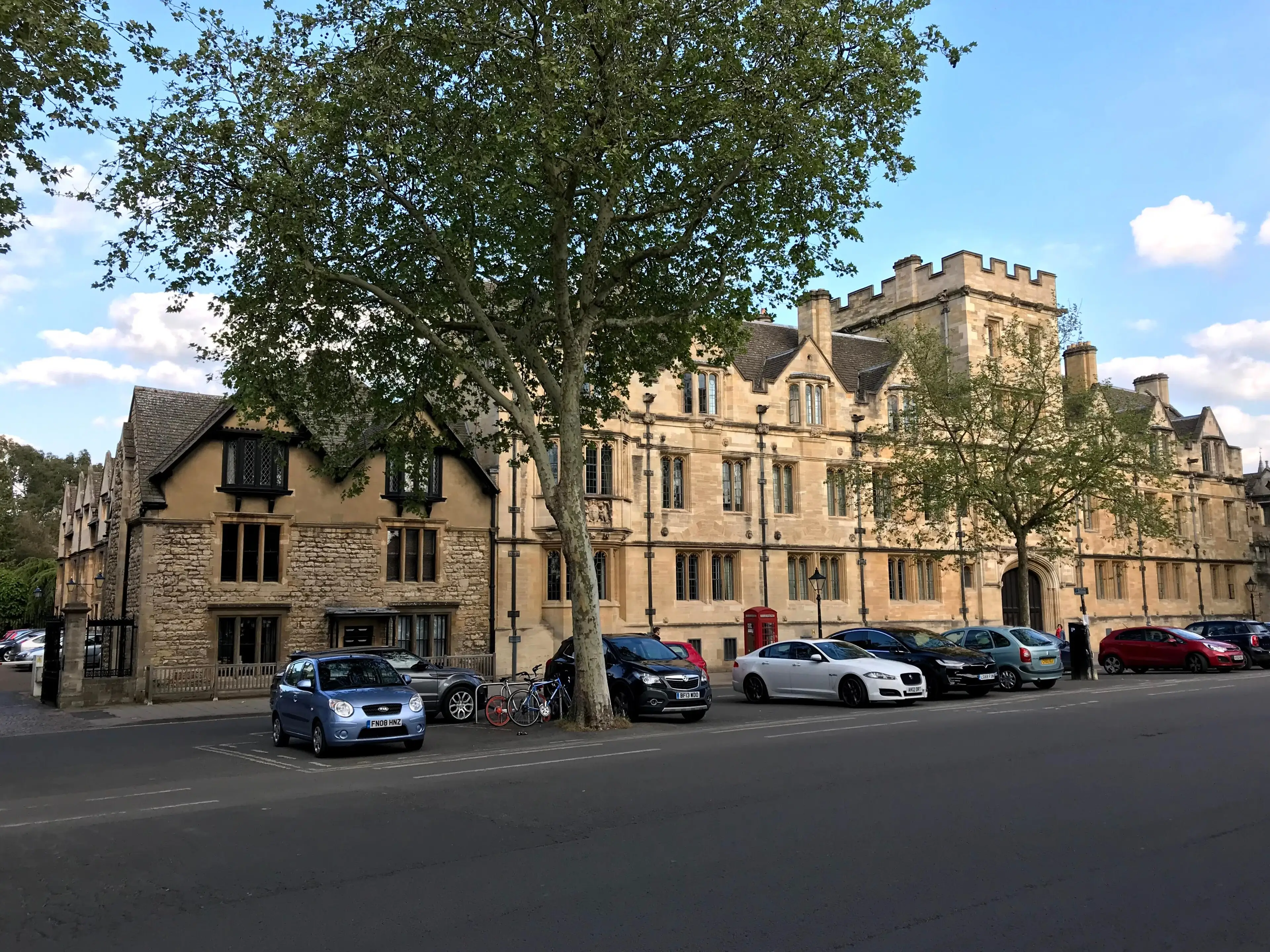 The St Giles' frontage of St John's College: a long battlemented stone range behind plane trees.